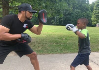 Photo of Boxing Trainer Zachary Thomas working with Shock-A-Bully student