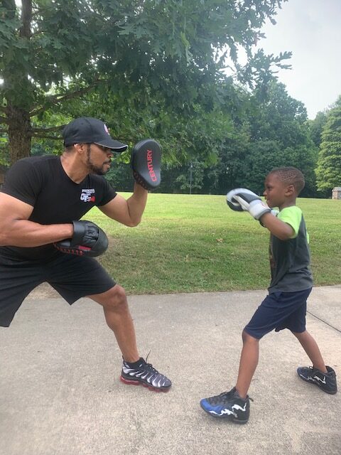 Photo of Boxing Trainer Zachary Thomas working with Shock-A-Bully student